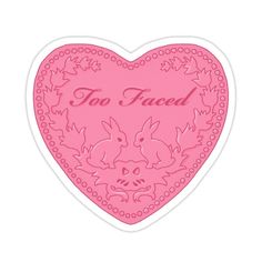 a pink heart shaped sticker with the words too faced on it