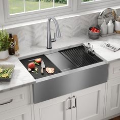 a stainless steel sink in a kitchen with marble counter tops