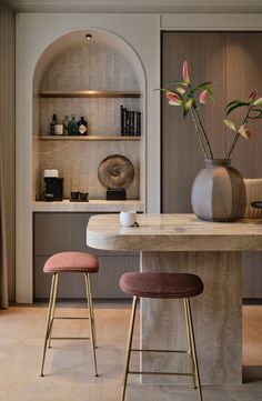 two stools sit in front of a marble table