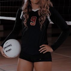 a female volleyball player is posing with her ball