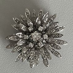 Flower pendant brooch in white gold (18k) set with brilliant-cut and 8/8-cut diamonds. The central diamond measuring approximately 0.15 ct, surrounded by 6 diamonds in a mobile spiral. Total diamond weight: approximately 1.10 ct. Diameter: 35mm. Gross Weight: 16.00 g And many other great brooches on our website: www.ohmybrooch.com Further information : We issue an invoice as well as a certificate of authenticity established by our qualified gemologist (LFG Paris). Our photos are not reworked and Diamond Flower Pendant, Pendant Brooch, Diamond Flower, Flower Pendant, Vintage Brooches, Natural Light, Brooch Pin, Brooches, Gold Diamond