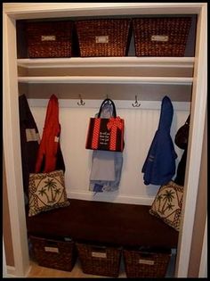 a closet with baskets and coats hanging on the wall next to an entryway bench