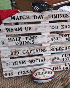 a wooden sign sitting on top of a table next to a soccer ball and glove