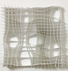 an abstract sculpture made out of white paper with wavy lines on the sides and bottom