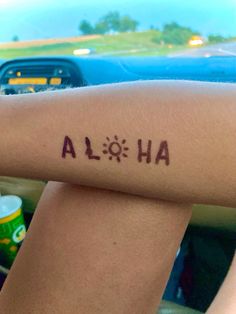 a person with a tattoo that says aloh on their arm and the word aloh written in red ink