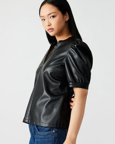 The JANE top boasts a contemporary design with a touch of femininity. Its soft faux leather fabric provides structure to the short puff sleeve pullover style. The split V-neck collar and half-length puff shoulder complete its sleek and polished look. V-neck faux leather top Unlined with soft inner facing Length: 23.5" 100% polyurethane Care instructions: wipe clean with a damp cloth, do not bleach, line dry, use pressing cloth and iron on low if necessary, do not dry clean Shop the set here Mari Fitted Faux Leather Top For Work, Fitted Faux Leather Tops For Work, Faux Leather Tops For Spring Workwear, Faux Leather Tops For Work In Spring, Faux Leather Top For Work In Spring, V-neck Black Puff Sleeve Top For Fall, Leather Collared Top With Pockets, Classic Leather Collared Top, Black Leather Short Sleeve Shirt