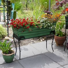 a green bench sitting next to some potted plants