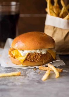 a fried chicken sandwich with cheese and fries