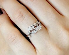 a woman's hand with a diamond ring on her left and an engagement band on her right