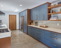 a kitchen with blue cabinets and white counter tops