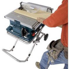 a man is working on a table sawing with a portable stand and tool box