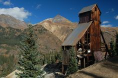 an old wooden building on the side of a mountain