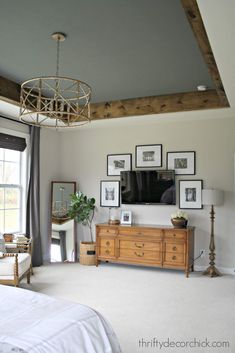 a living room with pictures on the wall and a bed in front of a window