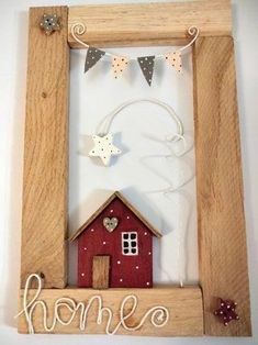 a wooden frame with a red house and bunting on the side that says home