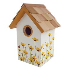 a white birdhouse with yellow flowers painted on it's side and a brown roof