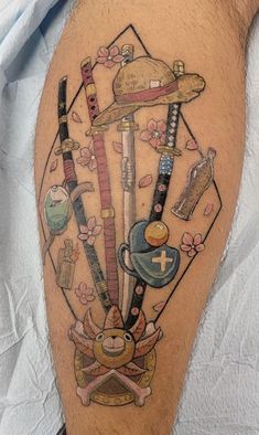 a man's leg with tattoos on it and various items in the shape of an umbrella