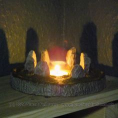 a lit candle in the middle of some rocks