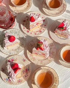 there are many pieces of cake on plates with tea cups and saucers next to them