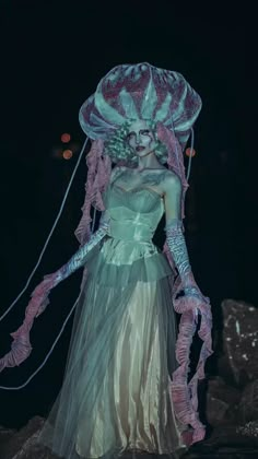 a woman dressed up as a jellyfish in the dark with her hair pulled back