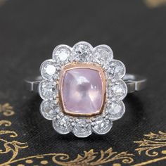 Cluster rings are a wonderful way to incorporate colored gemstones and diamonds into a piece of jewelry that is wearable just as is beautiful! A beautiful color contrast is this pink sapphire set in a halo of crisp, white old mine cut diamonds. The sugarloaf itself is bezel set in warm yellow gold, which kooks so pretty against the soft pink of the stone. All of the diamonds in platinum sparkle effortlessly, altogether making for the sweetest ring ever. Platinum and 18kt yellow gold bezel Size 6 Heirloom Pink Jewelry With Center Stone, Pink Ruby Ring With Platinum, Pink Platinum Ruby Ring, Oval Pink Platinum Jewelry, Pink Oval Platinum Jewelry, Formal Pink Diamond Cluster Ring, Classic Pink Platinum Jewelry, Fine Jewelry Pink Diamond Ring In Platinum, Exquisite Pink Rings With Diamond Accents