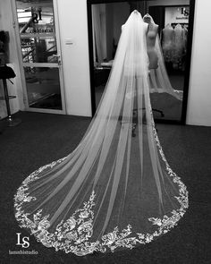 the back of a bride's wedding dress is shown in black and white photo