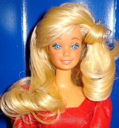 a barbie doll with blonde hair and blue eyes wearing a red dress in front of a blue door