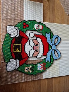 a cross stitch christmas ornament hanging on a wall