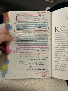 someone is holding an open book with writing on it and the pages are lined in different colors