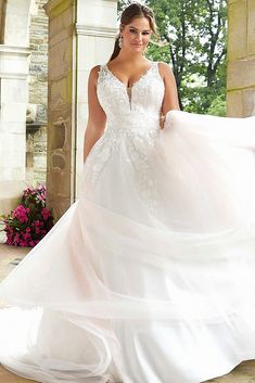 a woman in a wedding dress posing for the camera