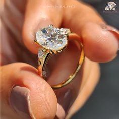 a person holding an engagement ring in their hand with the diamond on it's side