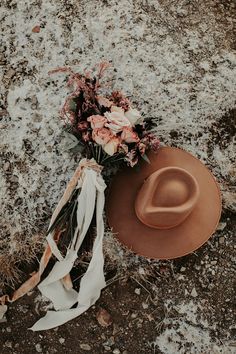 a hat and flowers on the ground