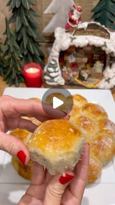 a person holding a piece of bread in front of a plate with christmas decorations on it