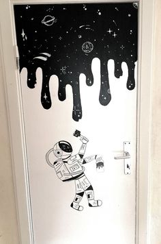 the door is decorated with an astronaut and stars on it's outer space theme