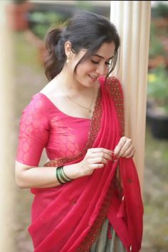 a woman wearing a red and grey sari