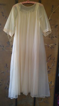 "60's lovely light beige nylon peignoir maxi nightie and sheer matching gown set. The nightie has beige lace shoulders and around front of the neck with brown eyelet embroidery across neck. The hem is lace also. The Gown is sheer double fabric. Same detail as nightie at front of the neck, it does up with two small buttons at the front of neck. mid length wide sleeves with lace at ends. Nightie : arm to arm across 18\" (36 bust) length 52\" **A few teeny tags in outer gown**" Cream Wedding Night Gown With Lace Trim, Cream Lace Wedding Nightgown, Wedding Cream Lace Nightgown, Sheer Cream Nightgown For Wedding Night, Vintage Beige Dress For Wedding Night, Sheer Lace Cream Nightgown, Cream Lace-trim Sleepwear For Wedding, Cream Wedding Sleepwear With Lace Trim, Fitted Cream Nightgown For Wedding