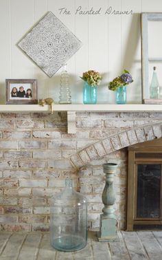 a brick fireplace with vases and pictures on it