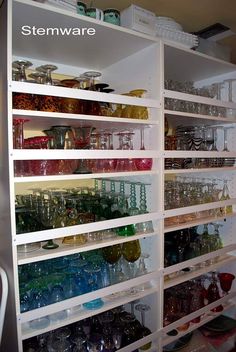 the shelves are filled with many different colored glass bowls and glasses on them, including one that is labeled stemware