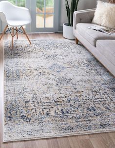 a living room area with a couch, chair and rug