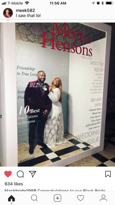 a man and woman standing next to each other in front of a poster for their wedding