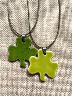 This necklace is a unique, handcrafted piece of jewelry...ready to stand out!  Wear it as a lucky charm and avoid getting pinched on St. Patrick's day! Dimensions Pendant: 3 leaf  W 1 5/8" x H 1 1/2" 4 leaf pendant is slightly smaller Thickness app 1/8" Color Pictured: Green thumb speckled, Sour apple speckled Necklaces are 18" green cording Nickel free Necklaces may vary depending on availability. Handmade in North Carolina Longer or different necklaces are available upon request.  I try to make each pendant a unique, handcrafted, & quality piece of jewelry for you. I ensure that they are flat, light weight, that the edges are soft, and the glaze application is even. Warning: Please keep away from small children and pets. The necklaces may present a choking hazard. The pendant is made out Green Nickel-free Pendant Charm Necklace, Green Charms Jewelry For Good Luck, Green Good Luck Charms Necklace, Nickel-free Green Flower Pendant Jewelry, Personalized Green Charm Necklace With Round Pendant, Adjustable Green Necklace As Gift, Personalized Green Round Pendant Charm Necklace, Personalized Green Round Pendant Necklace, Lucky Charm Necklace