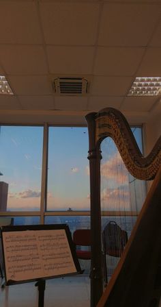 a harp sitting in front of a window next to a sign