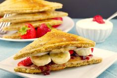 two plates with pancakes and strawberries on them