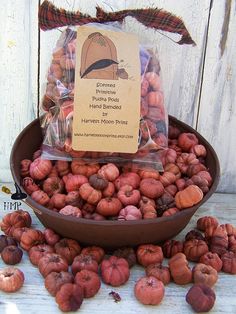 a bowl filled with lots of nuts on top of a wooden table next to a sign