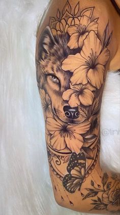 a woman's thigh with flowers and a wolf on it