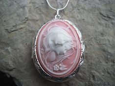 Beautiful cameo locket!!!  The cameo is beautifully detailed!!!  Wonderful gift for sisters, mothers, daughters, and friends!!!! The locket is victorian style with beautiful scroll on the front and back about 1 3/4" long.  It can hold two photos, keepsakes, or even your daily medication or vitamins!!! Pass down from generation to generation!!! The chain is 22"  1.2mm .925 plated snake chain with a lobster claw clasp!!! Perfect  for Brides or Bridal parties.  Makes a unique memorable gift for any Victorian Cameo Locket Necklace As A Gift, Cameo Medallion Locket Necklace Keepsake, Cameo Medallion Locket Necklace For Keepsake, Keepsake Medallion Locket Necklace With Cameo, Elegant Cameo Locket Necklace For Wedding, Wedding Locket Necklace For Mother's Day, Wedding Locket Necklace For Mother's Day With Round Pendant, Cameo Medallion Locket Necklace For Weddings, Pink Locket Jewelry For Mother's Day