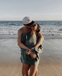 a man and woman kissing on the beach