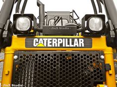 the front end of a yellow caterpillar tractor with lights on it's head