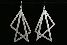 the earrings are made out of metal and have geometric shapes on them, as if they were