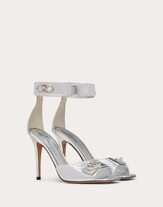 Valentino Garavani VLogo Locker sandal in mirrored calfskin - VLogo Signature swivel closure straps in tone-on-tone finish - Heel height: 105 mm / 4.2 in. - Made in Italy Luxury Sandals With 4-inch Heel And Single Toe Strap, Luxury Patent Leather Sandals With 4-inch Heel, Luxury Silver Patent Leather Sandals, Luxury Silver Sandals With Sculpted Heel, Luxury Silver Heels With Buckle Closure, Silver Patent Leather Sandals With Heel Strap, Elegant Silver Patent Leather Sandals, Luxury Buckle Closure Sandals For Gala, Luxury 4-inch Heel Ankle Strap Heels