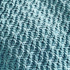 a close up view of a blue blanket that is made with yarn and crochet